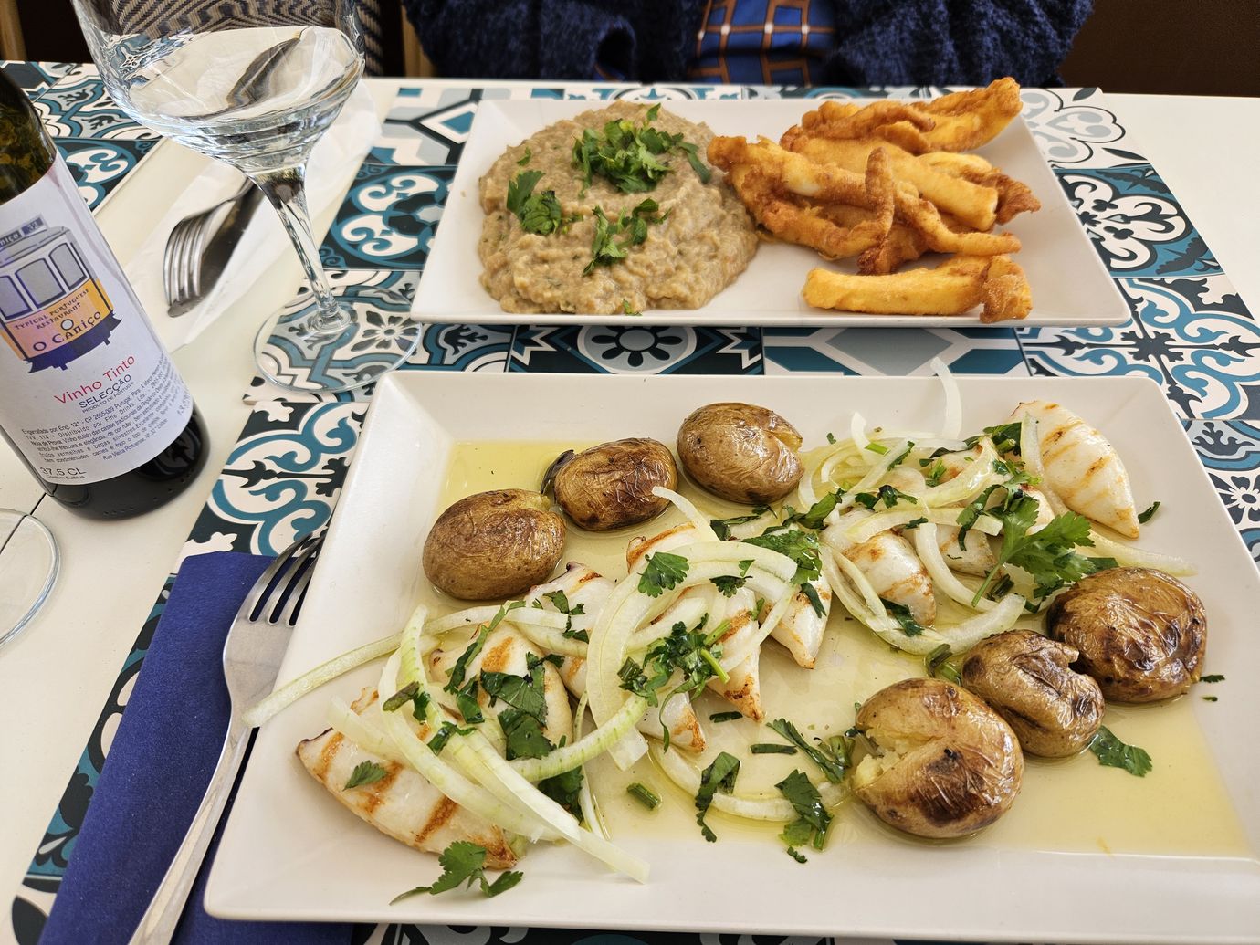 Choco frito and grilled squid served at a traditional Portuguese restaurant with azulejo tiles and local red wine
