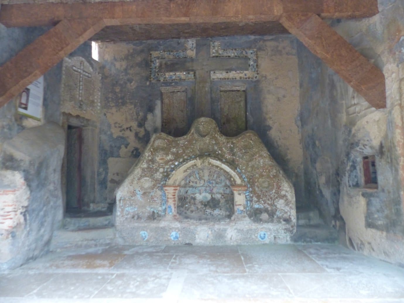 Cork-lined chapel interior with wooden cross inside the Convento dos Capuchos near Sintra
