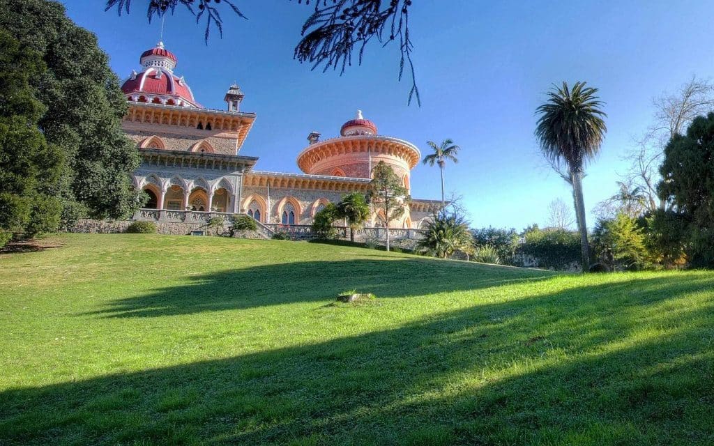 Monserrate Palace ornate domed towers rising above green lawns and palm trees near Sintra