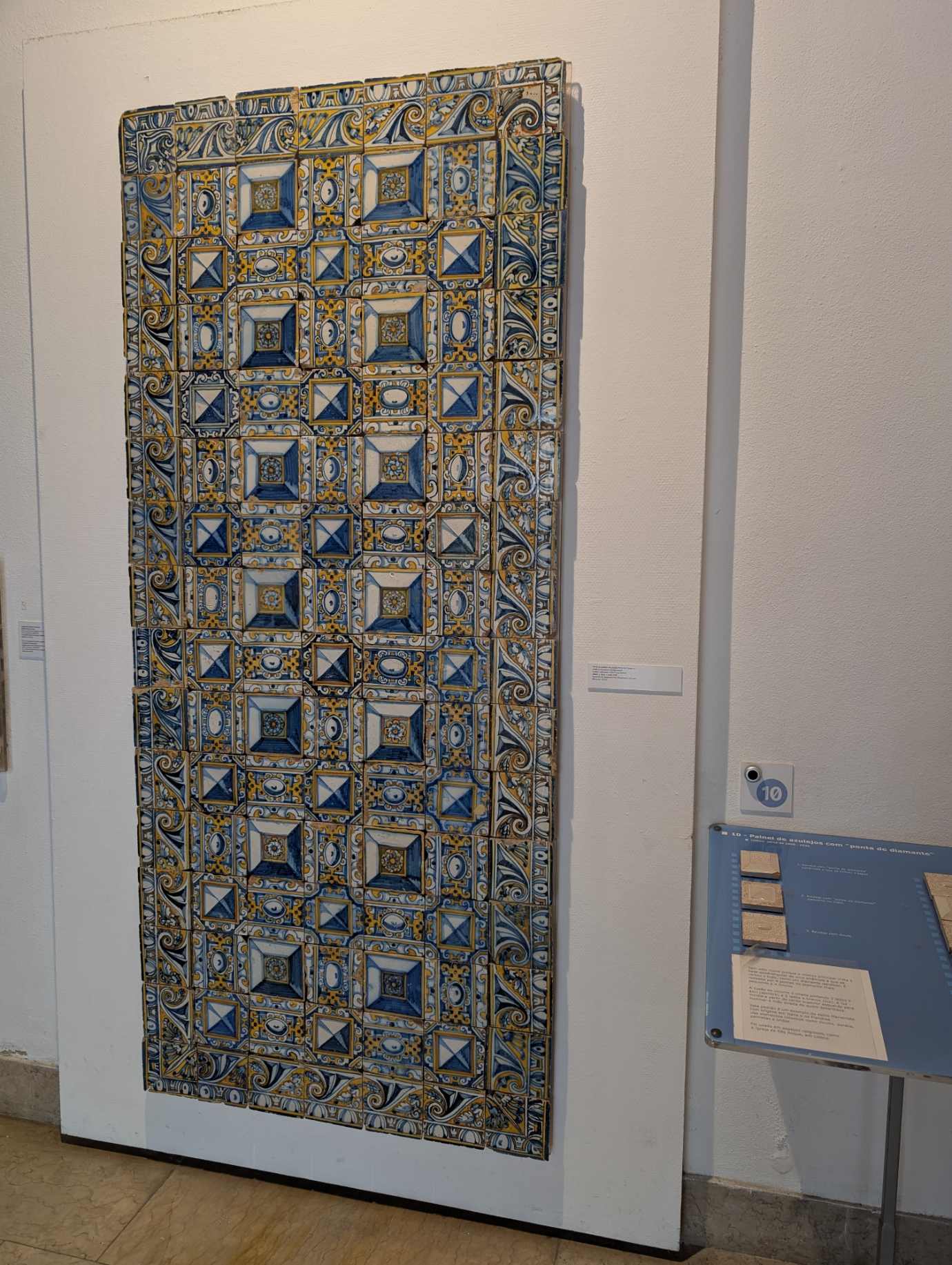 Colourful 17th-century diamond-tip pattern azulejo tile panel in blue and yellow, displayed at the Museu Nacional do Azulejo in Lisbon