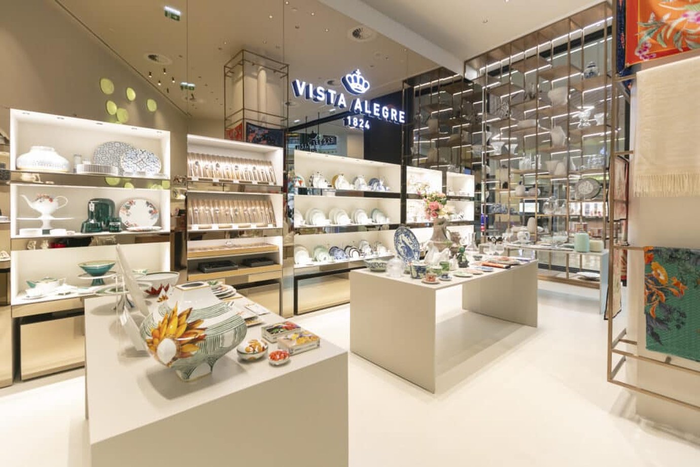 Elegant interior of a Vista Alegre porcelain store, with tableware displayed on shelves and tables