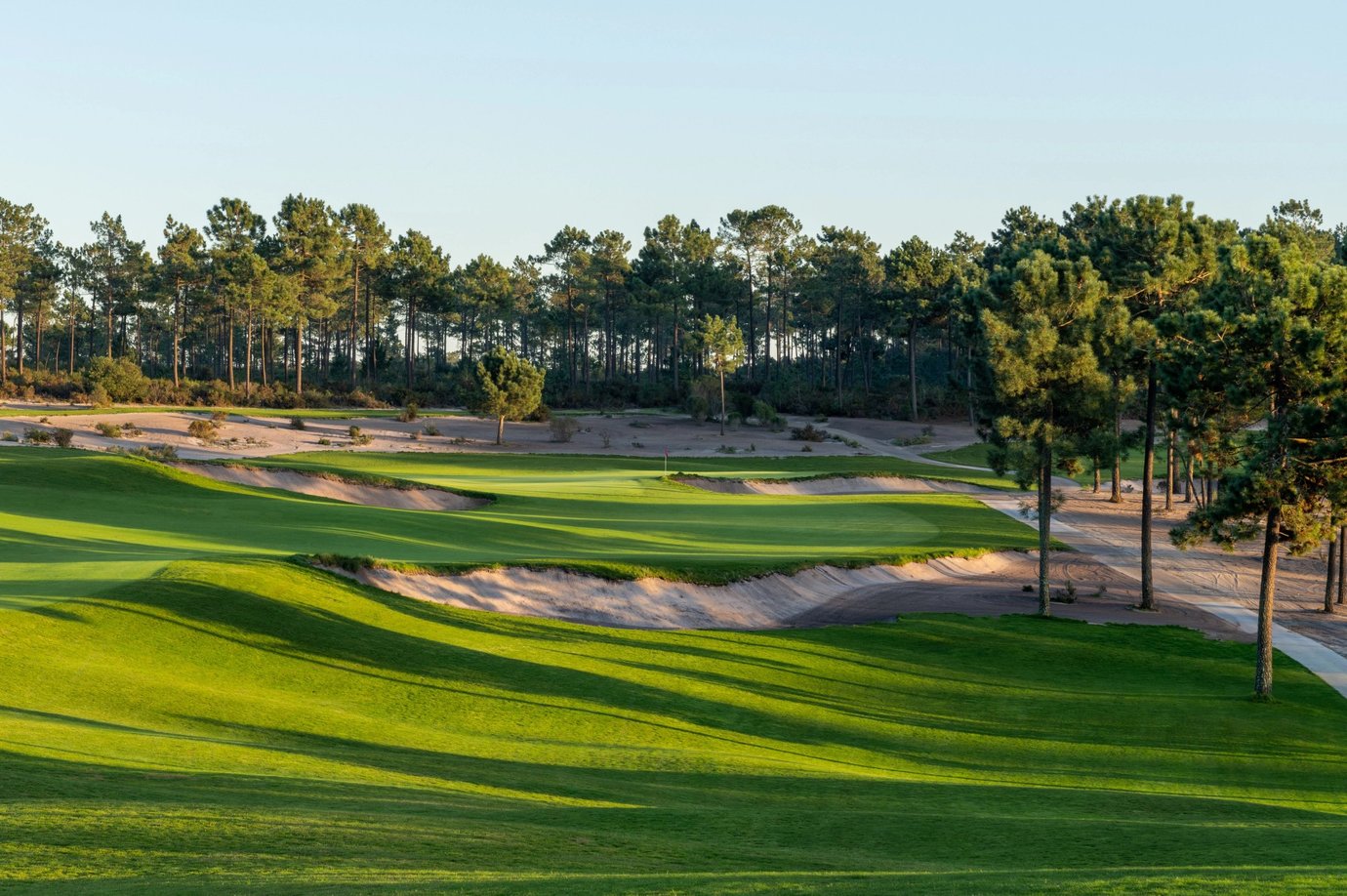Golden hour view of a fairway and bunkers at Dunas golf course, Terras da Comporta, Portugal