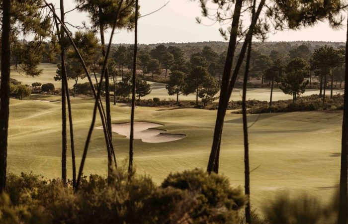Fairway and bunker at Pinheirinho Golf Course, framed by pine trees, Comporta, Portugal