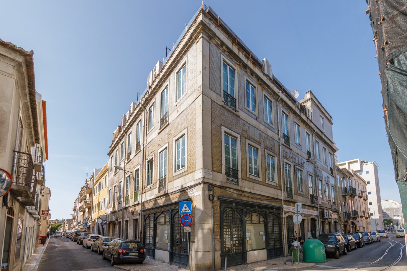 The tiled corner facade of the Panificação Mecânica bakery in Campo de Ourique, Lisbon, under a clear blue sky