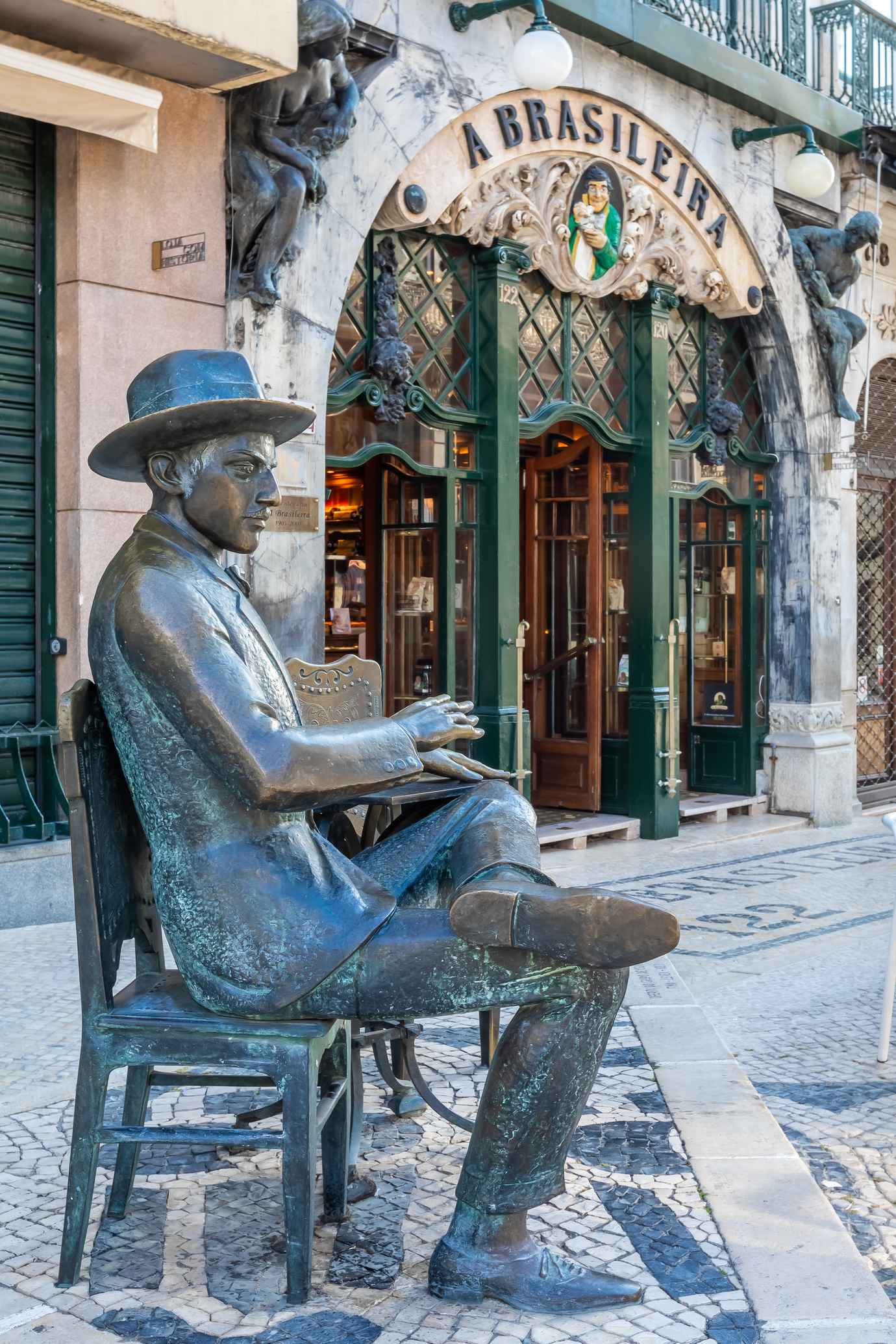 The bronze statue of Fernando Pessoa seated at a table in front of the entrance to A Brasileira in Chiado, Lisbon