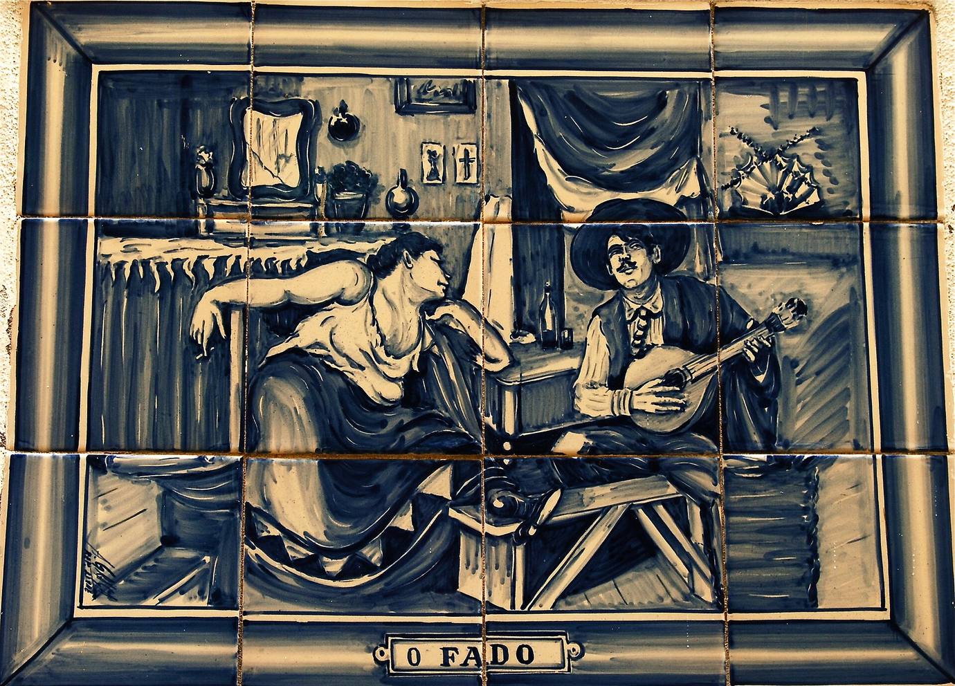 A blue and white azulejo panel titled O Fado showing a woman listening to a man playing a Portuguese guitar