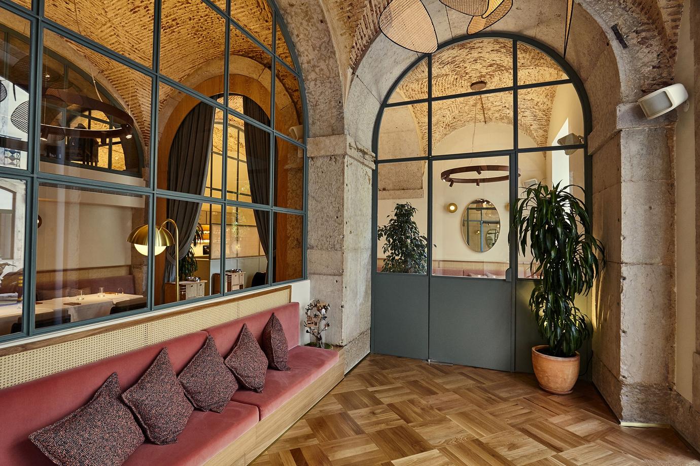 Arched windows, pink banquettes and parquet floors in the Belcanto dining room in Chiado, Lisbon
