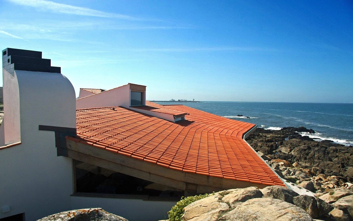 The orange tiled roof of the Casa de Chá da Boa Nova, designed by Álvaro Siza, above the rocks and sea at Leça da Palmeira near Porto