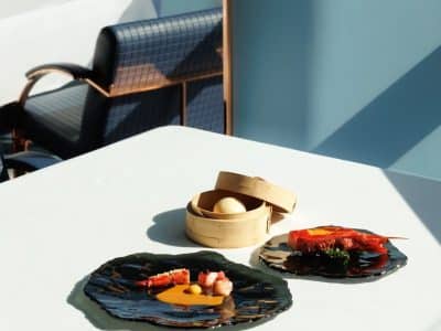 Michelin Hero Fifty Seconds Tasting menu dishes on a sunlit table in the blue dining room of Fifty Seconds, the two-Michelin-star restaurant in Lisbon